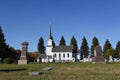 A white Lutheran church with a tall steeple located next to a cemetery Royalty Free Stock Photo