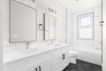 A white bathroom with a hexagon floor and subway tile shower.