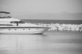 White luxury yacht, marine glides on sea surface. Modern expensive ship near rocky breakwater. Cruise and tourism Royalty Free Stock Photo