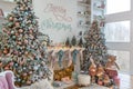 White living room with big windows and Christmas New year decor,light garland and Christmas tree with presents under it Royalty Free Stock Photo