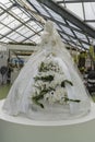 White magnificent dress of bride with white live lilies on a mannequin. Holiday of amazing colors and delicious flavors
