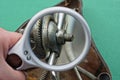A white magnifier in hand enlarges a gray nut and bolt Royalty Free Stock Photo