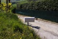 A white mailbox on the side of the road Pesaro, Italy Royalty Free Stock Photo