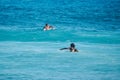 White man and black woman surfers swim on line up. Back view. Royalty Free Stock Photo