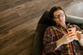 White man in glasses using mobile phone while resting on couch Royalty Free Stock Photo