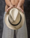 A white man in gray bermuda shorts covers his crotch with a straw hat Royalty Free Stock Photo