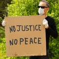 A white man holds a sign that says There is no justice, no peace in protest