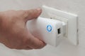 White man insert a wifi repeater in a wall plug Royalty Free Stock Photo