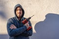 White man looking at the camera with an electric drill of batteries without wires to make DIY. Royalty Free Stock Photo