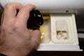 A white man`s male hand pours liquid powder from a black cap into the washing machine`s powder compartment. white and black colo Royalty Free Stock Photo