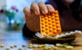 A white man taking tablets out of a heap of medicine