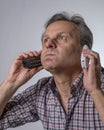 A man with two phones is fed up with being harassed over the phone with unwanted business proposals Royalty Free Stock Photo