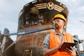 White man wearing helmet using tablet computer while working in port Royalty Free Stock Photo