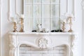 White mantelpiece with candles and christmas decorations. Classic interior. Royalty Free Stock Photo