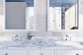 White marble bathroom sink with two mirrors