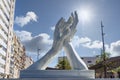 White marble clapping hands against sunny sky