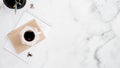 White marble home office desk with paper notebook, stationer and cup of coffee. Minimal flat lay style composition with copy space