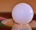 White marble orb on a cd disk closeup - stock photo Royalty Free Stock Photo