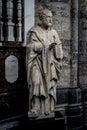 A white marble sculpture of an Scholar with a book in the interiors of Saint Nicholas Church, Ghent, Belgium