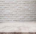 White marble stone tabletop, with defocus brick white wall texture background Royalty Free Stock Photo