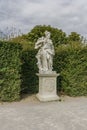 Classic white marble statue of woman with flute in green garden park. Ancient Roman or Greek woman stands on podium. the statue is Royalty Free Stock Photo