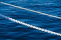 White marine mooring rope against background of blue water of Black Sea. Two white nautical cord. Background image Royalty Free Stock Photo