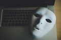 White mask placed on the laptop - concept fraud of social online