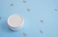White matte cream jar with plastic lid on blue background with stars Royalty Free Stock Photo