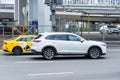 White Mazda CX-9 in motion blur on the street, side view. Japanese big crossover Mazda CX9 riding on the road with industrial
