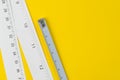 White measuring tapes with centimetre and inches on vivid yellow Royalty Free Stock Photo