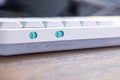 White mechanical keyboard featuring bright teal toggle switches for WIN MAC and OFF WIRED WIRELESS settings, facilitating Royalty Free Stock Photo