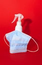 White medcine mask and bottle of desinfection on a red background Royalty Free Stock Photo