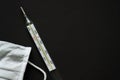 White medical disposable mask and mercury glass thermometer composition on a black background Royalty Free Stock Photo