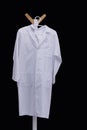 white medical gown hanging on wooden hanger