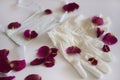 White medical mask and the latex gloves with a scattered rose petals