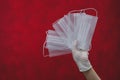 White medical masks in hand on a red background. preventive measures against respiratory illness and virus. hand in white surgical