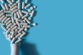 White medical pills on blue background. Royalty Free Stock Photo