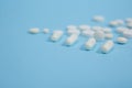 White medical pills on blue background Royalty Free Stock Photo