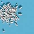 White medical pills on blue background. Royalty Free Stock Photo