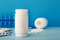 White medical pills and tablets spilling out of a bottle. Mock up bottles with copy space Royalty Free Stock Photo