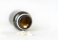 White medical pills and tablets spilling out of a drug bottle Royalty Free Stock Photo