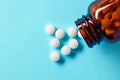 White medical pills and tablets spilling out of a drug bottle Royalty Free Stock Photo