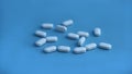 white medicinal pills isolated on the blue background