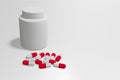 White medicine bottle and red-white capsule pill isolated on white background. Royalty Free Stock Photo