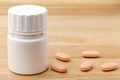 White medicine pills bottle on wooden table Royalty Free Stock Photo