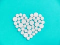 White medicine pills in the shape of a heart on  blue background top view with copy space. Royalty Free Stock Photo