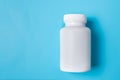 White medicine plastic package for pills. Bottle mockup on a blue background. Copy space Royalty Free Stock Photo