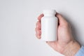 White medicine plastic package for pills in hand. White background. Pill Bottle, Packaging Mockup Royalty Free Stock Photo