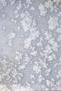 White melting frost on the frozen window glass in the cold winter day as natural background front view vertical