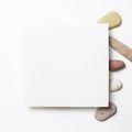 White memo pad, empty paper with pebble stones on white background